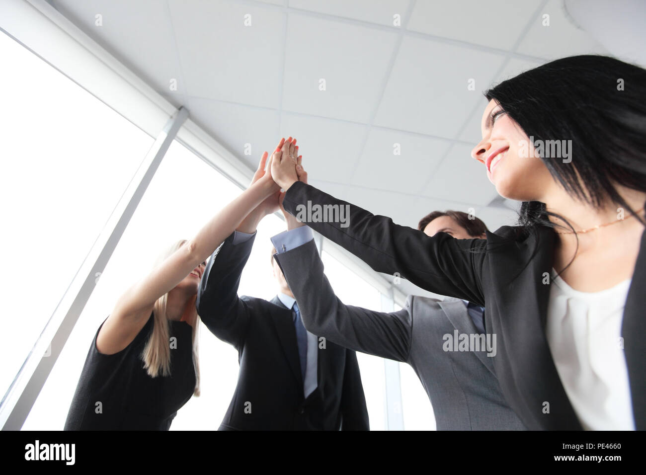 Happy smiling business people giving high five in the office Stock ...
