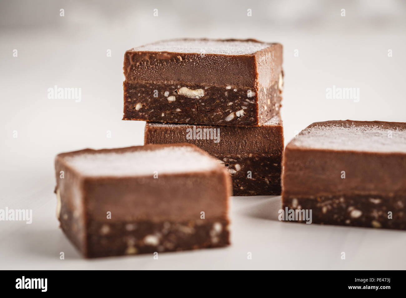 Chocolate fudge bars on white background. Clean eating concept. Raw vegan dessrt. Stock Photo