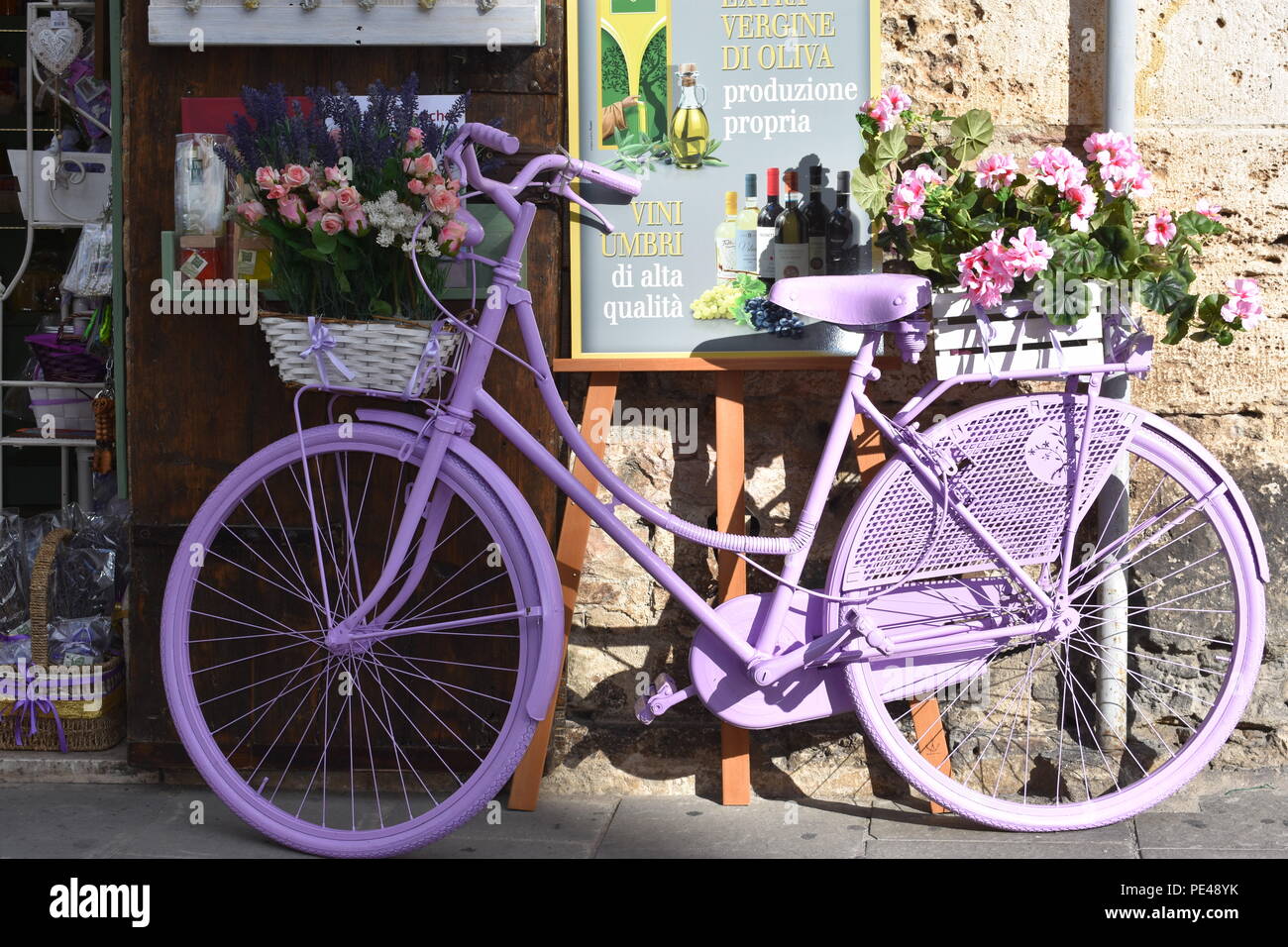 Pink / Lavender  bicylcle outside flower shop in Assisi Italy January 2018 Stock Photo