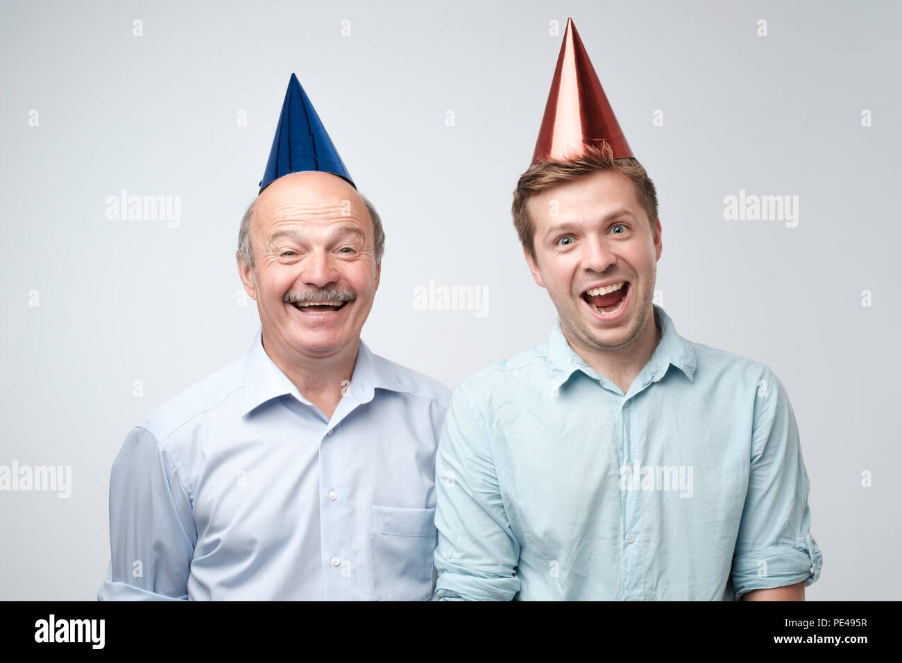 Mature man and his young son celebrating happy birthday wearing