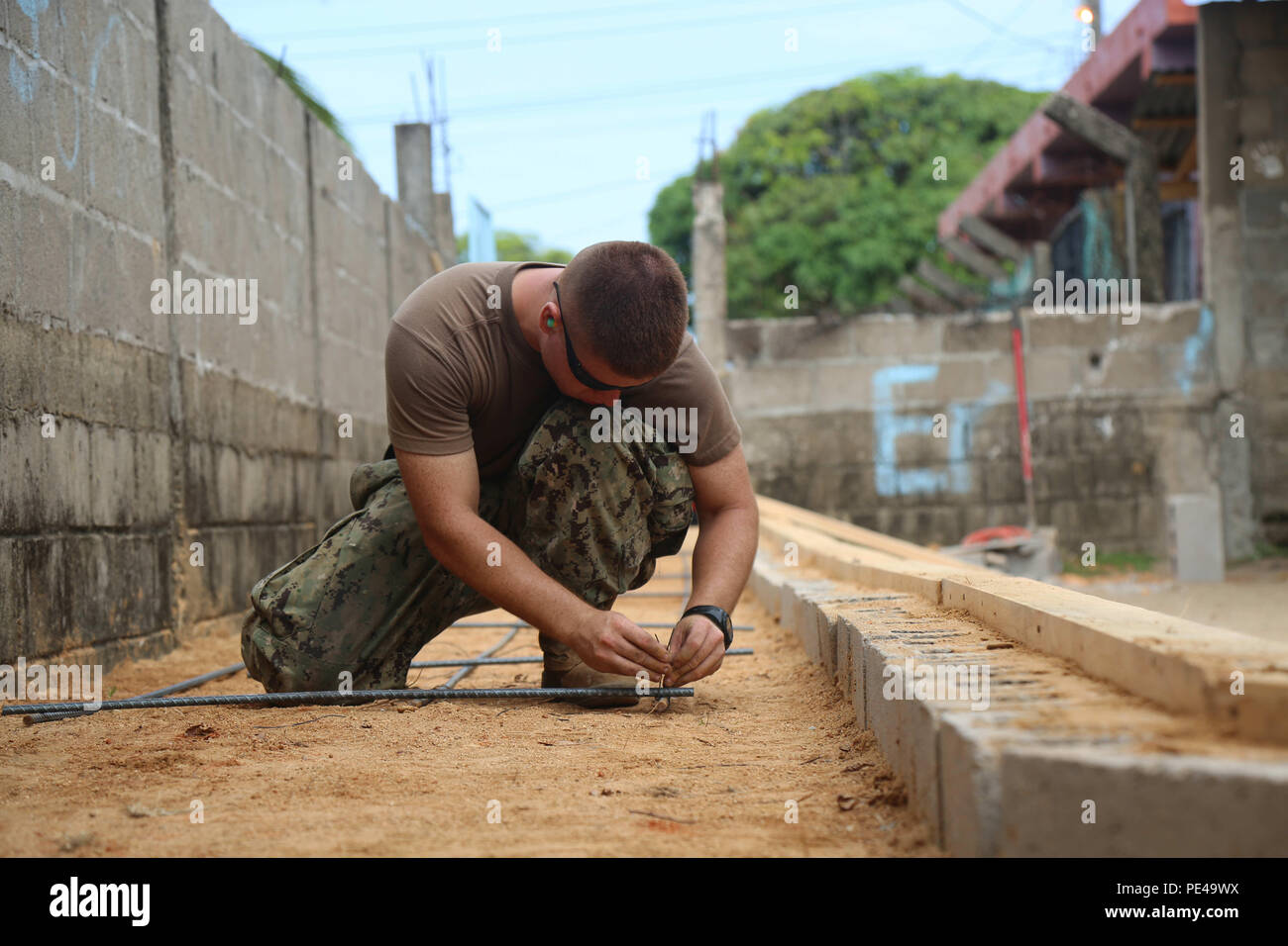 150902-A-ZA034-037 PUERTO CASTILLA, Honduras (Sept. 2, 2015) Steelworker Constructionman Apprentice Josue Batchelortorres, a native of Conroe, Texas, assigned to Construction Battalion Maintenance Unit 202 Jacksonville, Fla., secures rebar before laying cement at an engineering site established at the Centro Basico 14 de Agosto Lugar Puerto Castilla School during Continuing Promise 2015. Continuing Promise is a U.S. Southern Command-sponsored and U.S. Naval Forces Southern Command/U.S. 4th Fleet-conducted deployment to conduct civil-military operations including humanitarian-civil assistance,  Stock Photo
