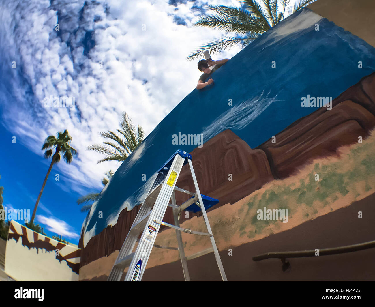U.S. Marine Corps Sgt. Ashleigh B. Gawat, a Marine Corps combat camerawoman, paints a Marine Corps and Arizona themed mural at the Civic Center in Scottsdale, Ariz., Sept. 7, 2015, to commemorate Marine Week Phoenix, Sept. 10-13. Gawat, a native of Griswold, Conn. is stationed at the Pentagon in Washington, D.C., and is taking on the large mural with four other Marines. Sept. 10-13, your Marines will perform band concerts, showcase equipment and aircraft, such as the MV-22 Osprey and AH-1Z Super Cobra, and engage in community service events. (U.S. Marine Corps photo by Sgt. Tyler J. Bolken) Stock Photo