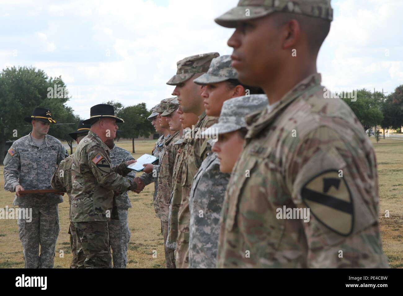 Soldiers from the 1st Cavalry Division military intelligence section gather  on Cooper Field at Fort Hood, Texas, and receive awards from Major Gen.  Michael Bills, commanding general, 1st Cavalry Division, for their