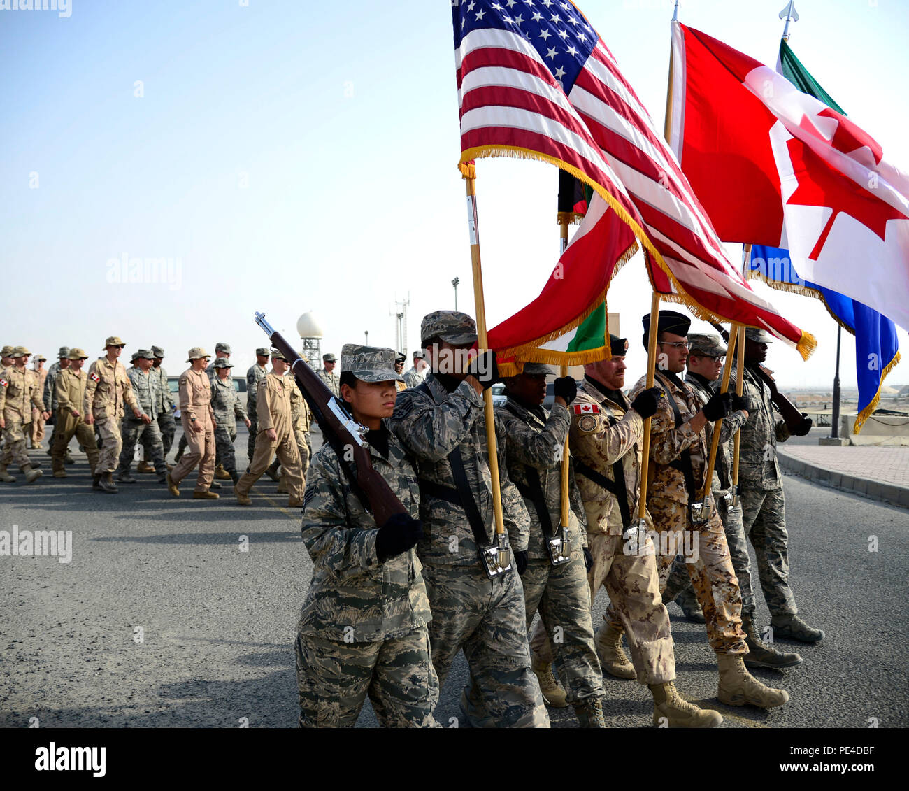 A coalition honor guard marches to a 9/11 memorial during a tribute ceremony at an undisclosed location in Southwest Asia, Sept. 11, 2015. Fourteen years after 9/11, America and its allies are still in the fight against acts of terrorism with Operation Inherent Resolve, the intervention against the Islamic State of Iraq and the Levant (ISIL). (U.S. Air Force photo by Senior Airman Racheal E. Watson/Released) Stock Photo