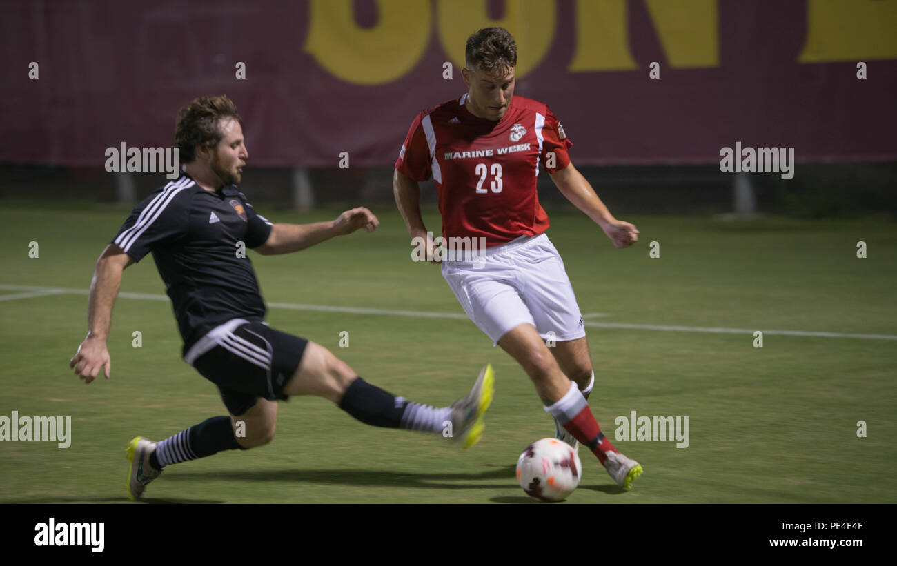 A Marine and Arizona State University soccer player fights for control of the soccer ball during a game between the All-Marine Team and the ASU Football Club at Sun Devil Soccer Stadium, Sept. 10, 2015, as part of Marine Week Phoenix. The people of Phoenix will be able to use Marine Week Phoenix to see the Marine Corps in a way that they would not normally see. Stock Photo