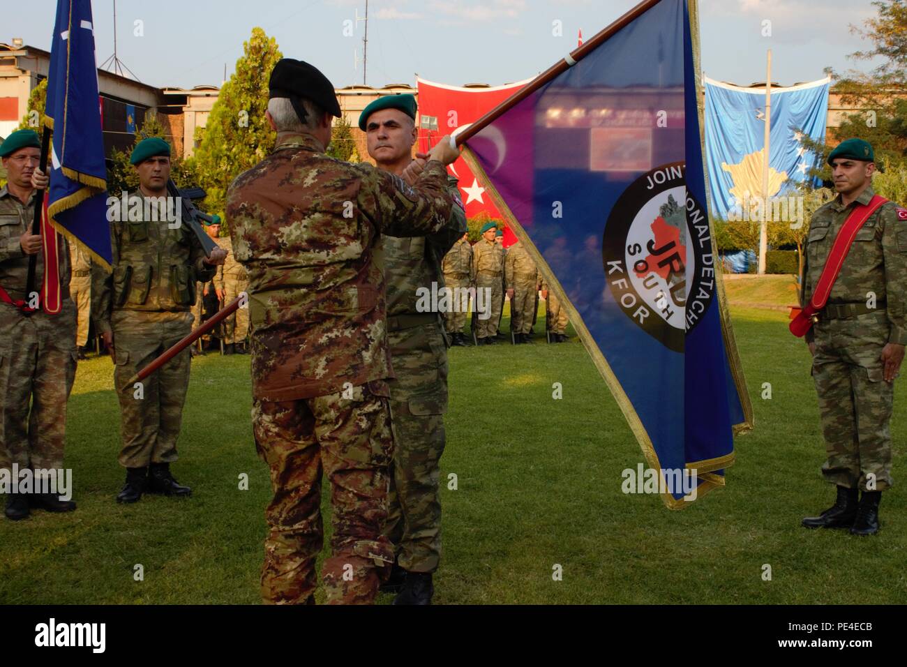Italian Maj. Gen. Guglielmo Luigi Miglietta, the Kosovo Force Commander, hands the Joint Regional Detachment-South colors to its incoming commander, Turkish Col. Saim Bagci, during a change of command ceremony Sept. 3, 2015, in Prizren, Kosovo. JRD-S and its liaison monitoring teams are part of KFOR, NATO’s peace support mission in the region. (U.S. Army photo by Sgt. Erick Yates, Multinational Battle Group-East) Stock Photo