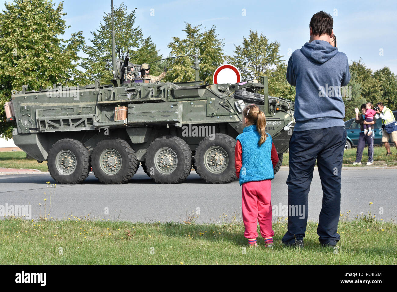 Families local to the Czech Republic wave as they cheer on Troopers assigned to 4th Squadron, 2nd Cavalry Regiment, while watching them participate in Dragoon Crossing, a tactical road march starting out at Rose Barracks, Germany and continuing through the Czech Republic and the Slovak Republic ending in Hungary Sept. 13, 2015. The purpose of the exercise is to reassure NATO allies of the U.S. intent during Operation Atlantic Resolve while demonstrating interoperability and freedom of movement throughout Eastern Europe. (U.S. Army photo by Sgt. William A. Tanner/released) Stock Photo