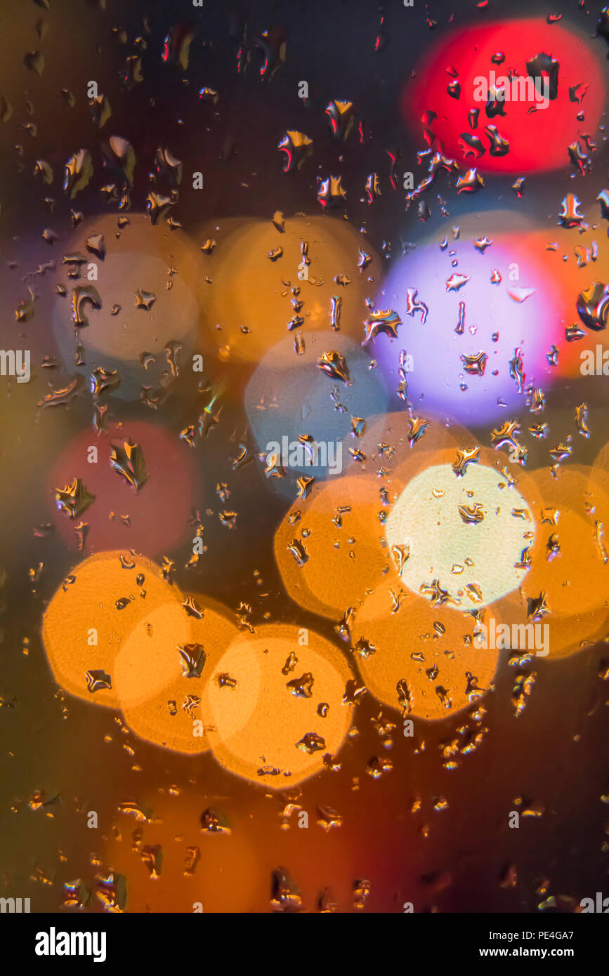 Raindrops on window with colorful bokeh background Stock Photo