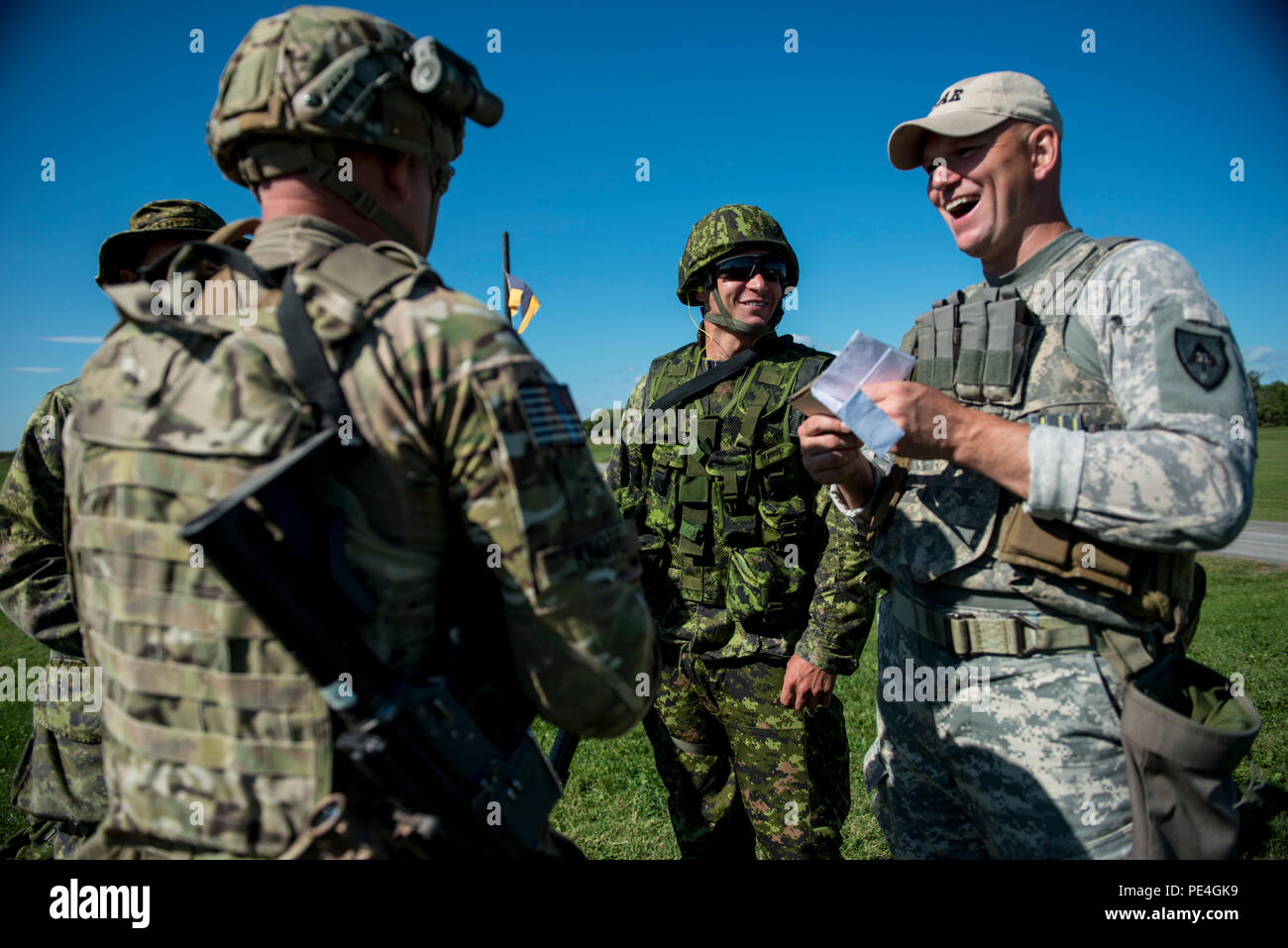Chief Warrant Officer Two Andy Knote (left), of North Chicago, and Staff Sgt. Jason Godel, of San Antonio, U.S. Army Reserve International Combat Team competitors, joke around with Canadian Army soldiers before taking on a 7-kilometer Rifle Military Biathlon match involving several physical obstacles during the 2015 Canadian Armed Forces Small Arms Concentration at the Connaught Range outside of Ottawa, Canada, Sept. 14. The international marksmanship competition lasted roughly two weeks, bringing in more than 250 total competitors from the British, Canadian and U.S. armed forces competing in  Stock Photo