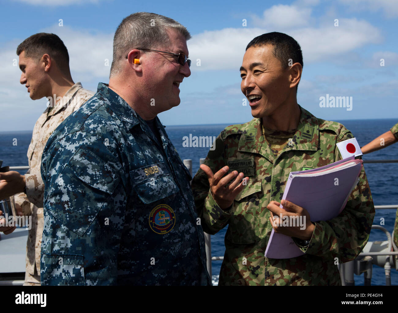 U.S Navy Captain Lance Snider, speaks with Maj. Toshinori Ushida, Japanese Ground Self Defense-Force tactics instructor, aboard the amphibious assault ship USS Boxer (LHD 4) during Exercise Dawn Blitz 2015, Sept. 4, 2015. Dawn Blitz is a scenario-driven exercise designed to train the U.S. Navy and Marine Corps in amphibious operations while building U.S. and coalition interoperability. (U.S. Marine Corps photo by Lance Cpl. April L. Price/Released) Stock Photo