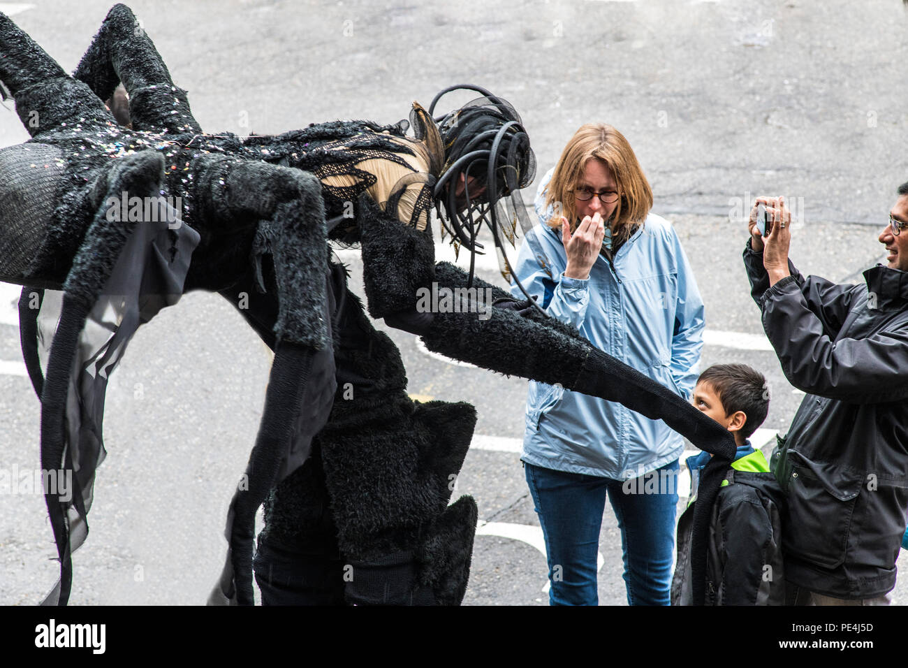 Giant black spider greeting little boy, man taking picture, woman, Strasbourg carnival parade, Alsace, France, Europe, Stock Photo