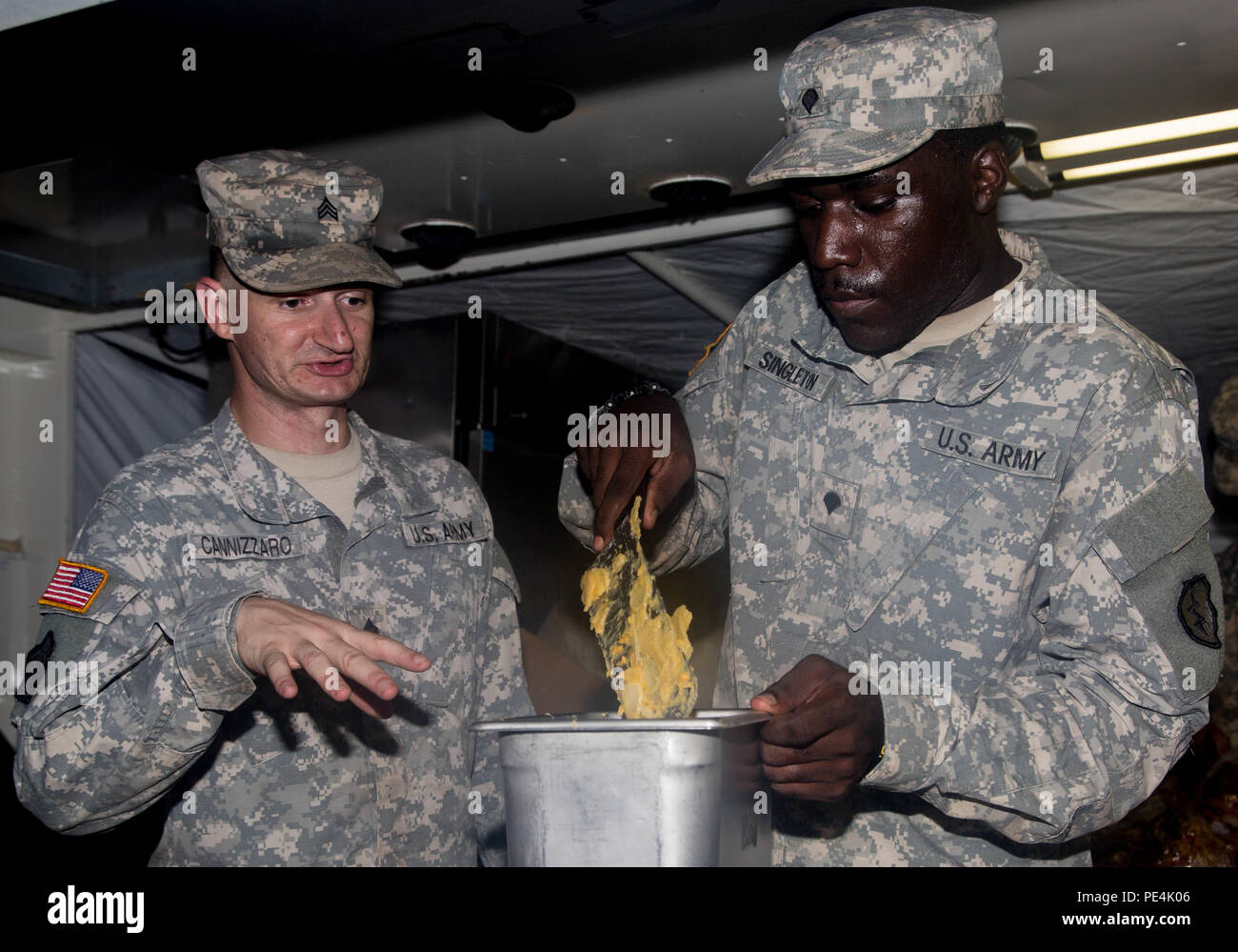 Sgt. Andrew Cannizaro, a food service specialist with Company F, 225th Brigade Support Battalion, 25th Infantry Division, coaches his Soldier, Spc. Gerron Singleton, on the proper way to prepare food Sept. 14 for over 500 Soldiers from 2 SBCT at East Range. A team of nine food specialists from Company F led by Staff Sgt. Derrick Lewellen prepare an evening meal for 2 SBCT Soldiers as well as train for their upcoming Field Conley Competition on Sept. 29. (U.S. Army photo by Sgt. Ian Ives, 2nd Stryker Brigade Combat Team Public Affairs/Released) Stock Photo