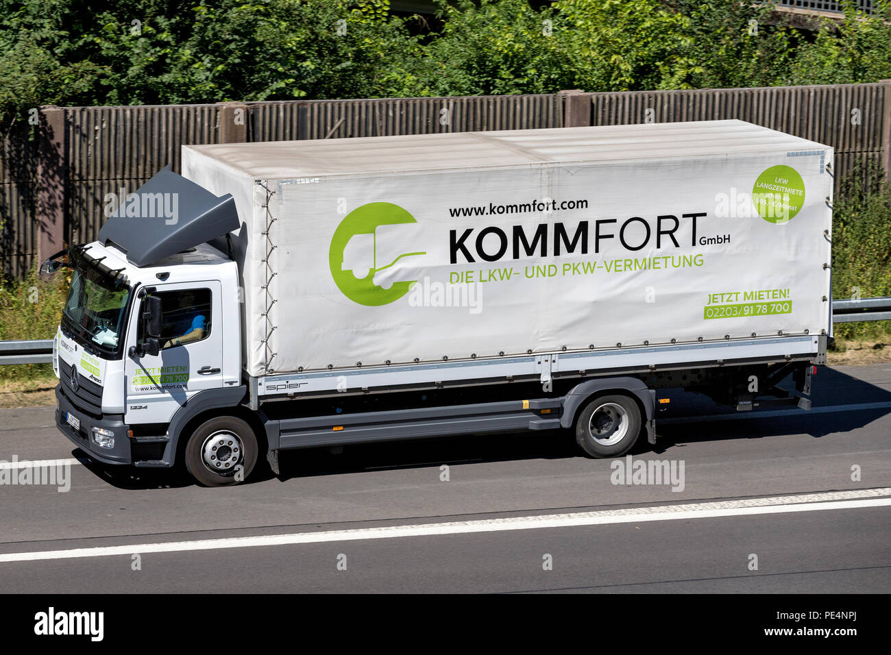 Mercedes-Benz Atego of KommFort on motorway. KommFort is a German truck rental and service company, with headquarters in Cologne. Stock Photo