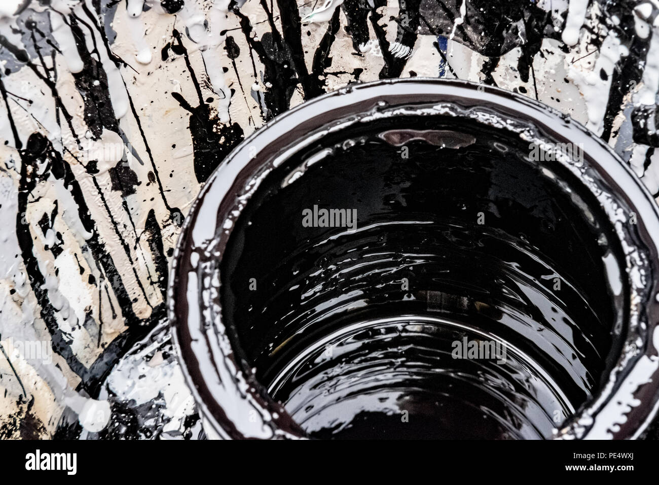 Closeup, shallow focus image of a nearly empty tin of black gloss paint used in home decorating