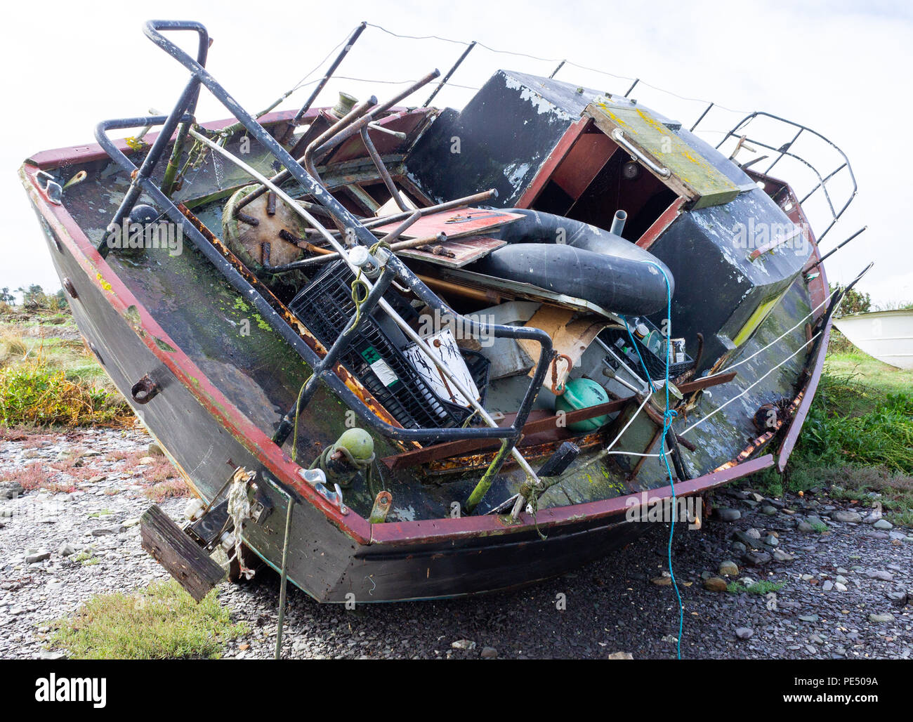 rusty, rusting wrecked hull tied up on a creek shore line. Stock Photo