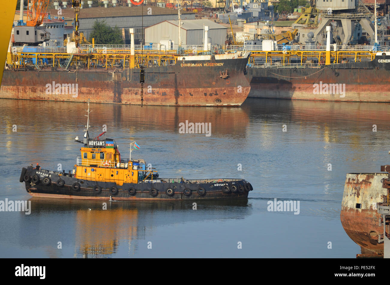 Tugboat amongst rusty vessels in Bibiheybat shipyard, Baku (Azerbaijan), Caspian Sea Stock Photo