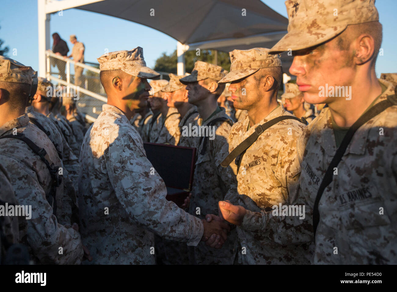 A Drill Instructor Present An Eagle Globe And Anchor Emblem To Pvt Orlando J Granell Iii