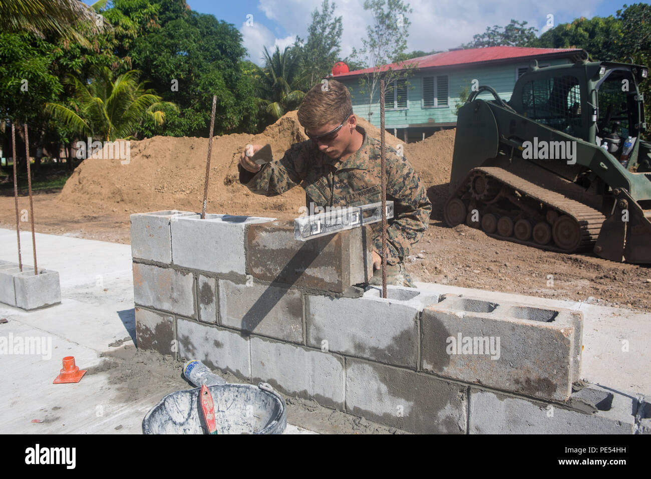 U.S. Marine Corps Lance Cpl. Silas Weibel, a combat engineer with Special Purpose Marine Air-Ground Task Force-Southern Command removes the excess mortar from the concrete block during the construction of the school Victor Hugo in Puerto Lempira, Honduras on Sept. 14, 2015. SPMAGTF-SC is a temporary deployment of Marines and Sailors throughout El Salvador, Guatemala, and Belize with a focus on building and maintaining partnership capacity with each country through shared values, challenges, and responsibilities. (U.S. Marine Corps photo by Cpl. Shakeasha J. Payton/Released) Stock Photo