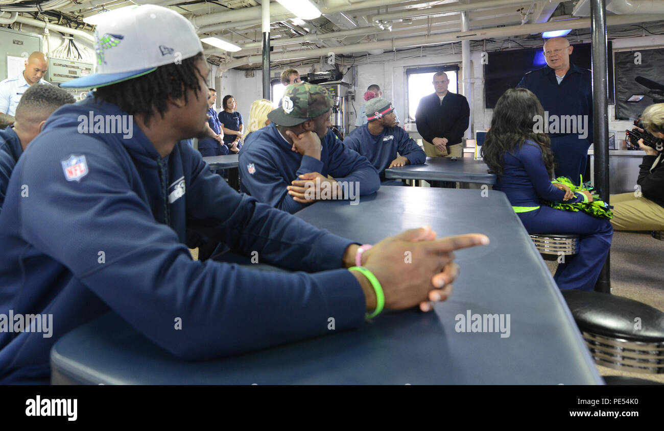 Rear Adm. Richard Gromlich, commander, Coast Guard 13th District, addresses a group of Seattle Seahawks players and Sea Gals during a tour of Coast Guard Cutter Mellon, a 378-foot High Endurance Cutter homeported in Seattle, Oct. 13, 2015. The tour was part of a change-of-command event at Coast Guard Base Seattle, during which the Coast Guard 13th District passed on the 12 Flag to the Marine Corps, Marines Security Forces Battalion–Naval Base Kitsap-Bangor, after a year as the Seahawks' honored military unit. (U.S. Coast Guard photo by Seaman Sarah Wilson) Stock Photo