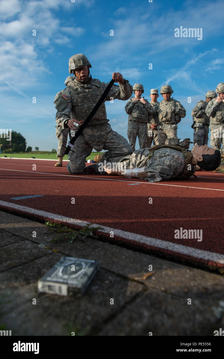 U.S. Army Staff Sgt. Erik Poveda, with Allied Forces North Battalion, U.S. Army NATO Brigade, explains how to apply a tourniquet on a training mannequin to Soldiers with 128th Signal Company and Headquarters and Headquarters Detachment, 39th Signal Battalion, during the Combat Life Saver part of Battalion Commander's Prime Time Training, on Chièvres Air Base, Chièvres, Belgium, Sept. 21, 2015. (U.S. Army photo by Visual Information Specialist Pierre-Etienne Courtejoie/Released) Stock Photo