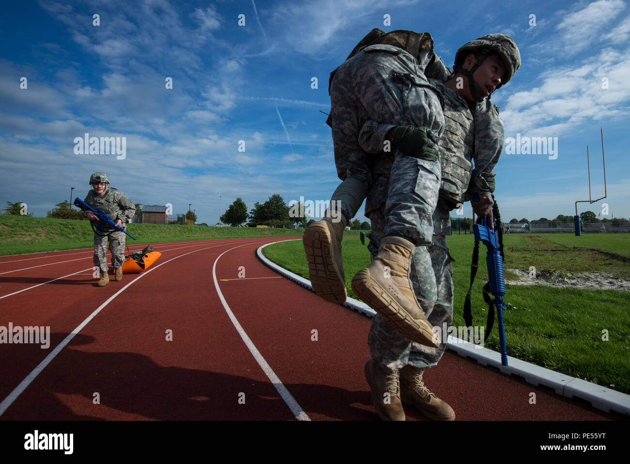 U.S. Army Sgt. Erik Fuentes, right, Headquarters and Headquarters Detachment (HHD), 39th Signal Battalion, carries a casualty as Spc. Gabriel Perez, also with HHD, evacuates another casualty on a flexible stretcher during the Battalion Commander's Prime Time Training, Chièvres Air Base, Chièvres, Belgium, Sept. 21, 2015. (U.S. Army photo by Visual Information Specialist Pierre-Etienne Courtejoie/Released) Stock Photo