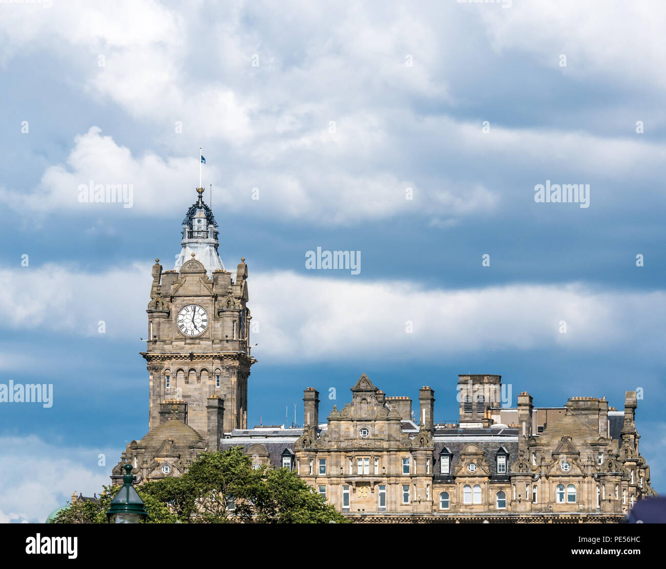 Victorian style Rocco Forte Balmoral Hotel clock tower and building against dramatic blue and white sky, Princes Street, Edinburgh, Scotland, UK Stock Photo