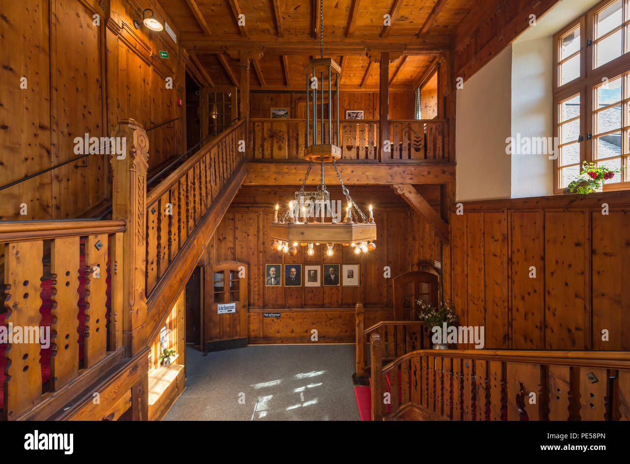 Splendid, wood-paneled entrance hall with chandelier and red carpet of the mountain lodge 'Berliner Hütte' in the Zillertal, Austria Stock Photo