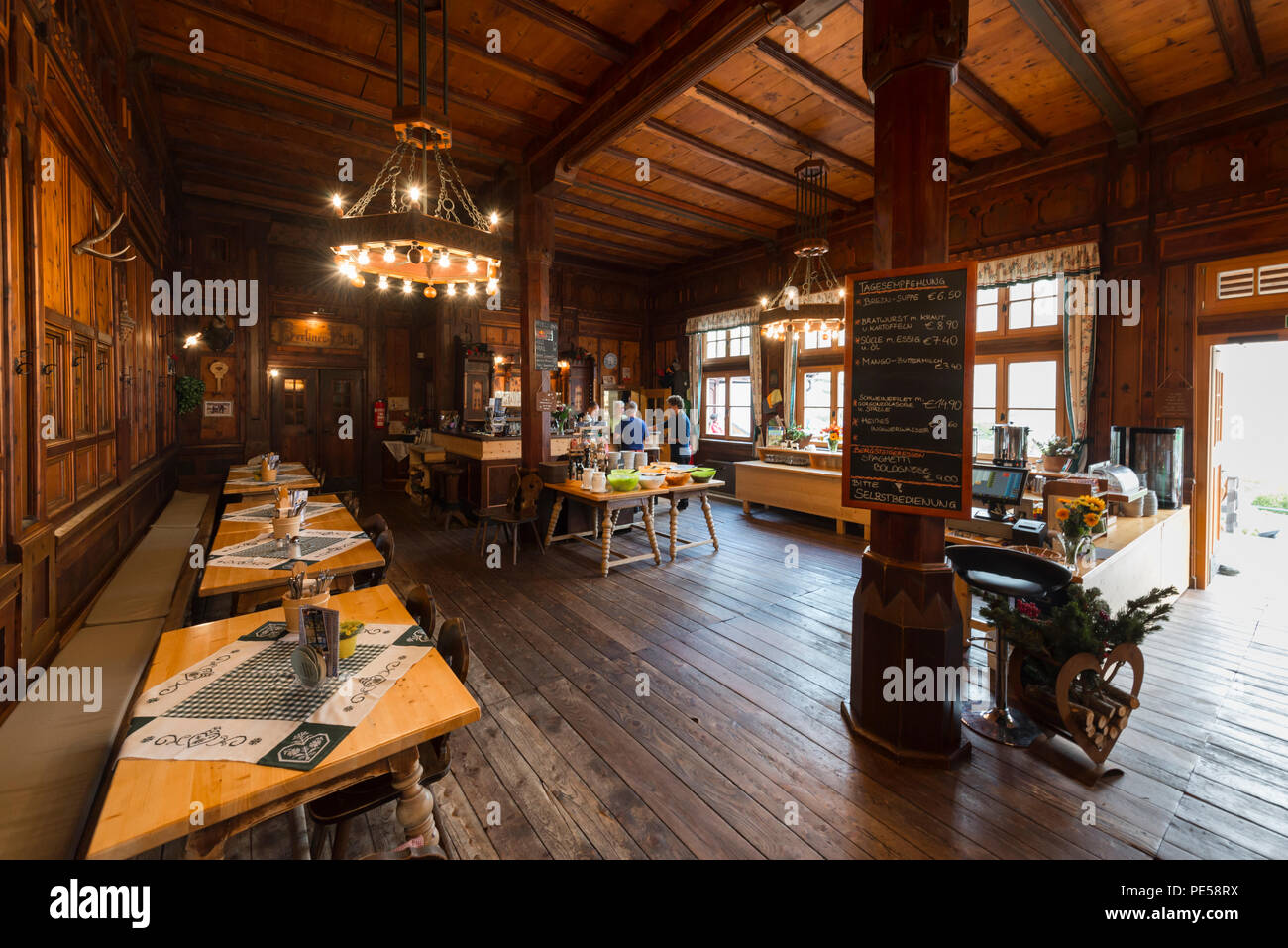 A splendid dining room with high wood ceiling and wood-paneled walls in the landmarked Berliner Hütte at Zillertal, Austria Stock Photo