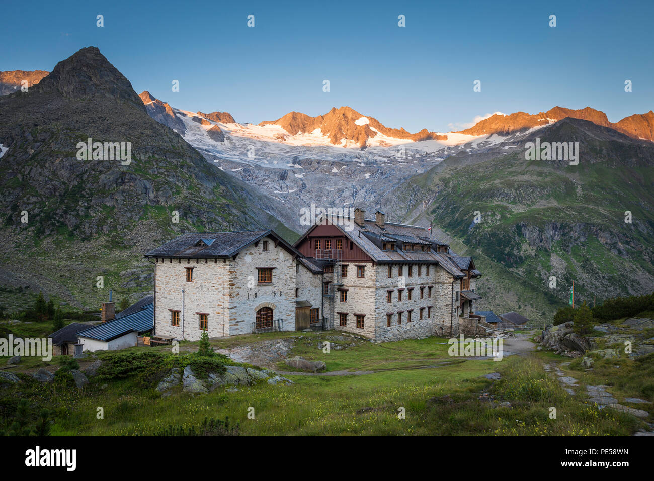 Historic Berlin Hut in the Zillertal with first sunlight on the Waxegkees glacier, Mount Grosser Moeseler and the Schoenbichler Horn, Austria Stock Photo