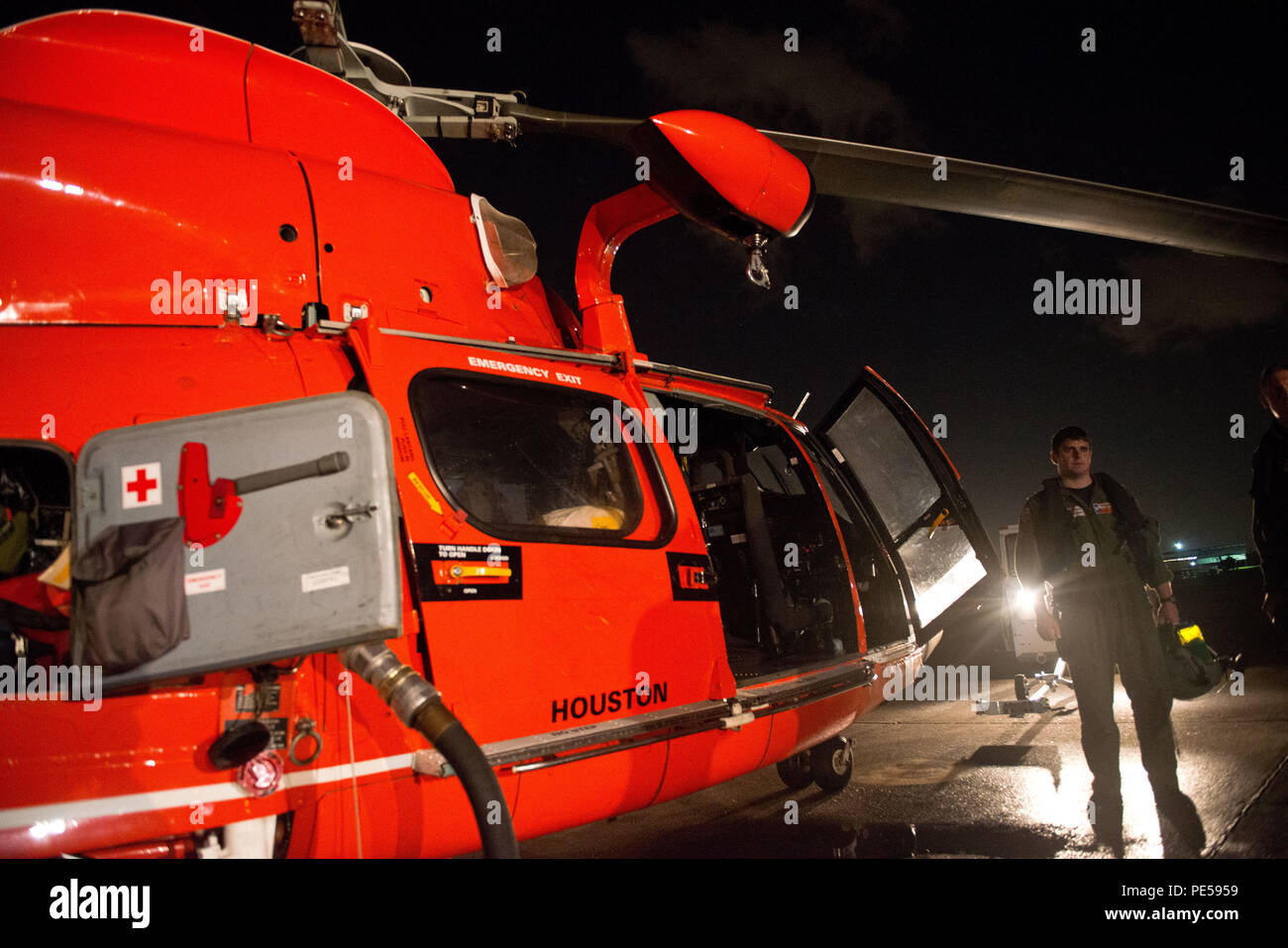 Lt. Zach Gross, an MH-65 helicopter pilot, disembarks the aircraft after a training flight at Air Station Houston, Sept. 29, 2015. Night operations training prepares air crews for the daunting task of performing a rescue with very little light and low visibility. (U.S. Coast Guard photo by Petty Officer 3rd Class Dustin R. Williams) Stock Photo