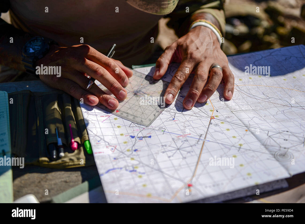 British army Sgt. Daniel Campbell, Royal Lancers joint tactical air controller, uses a protractor, map and navigation skills to plan preemptive targets at Barry M. Goldwater Range, Ariz., Sept. 23, 2015. The British armed forces JTACs are the link between air and ground communications and are charged with ensuring that they can direct any ordnance that leaves an aircraft while protecting civilians and friendly troops at all times. (U.S. Air Force photo by Airman 1st Class Chris Drzazgowski/Released) Stock Photo