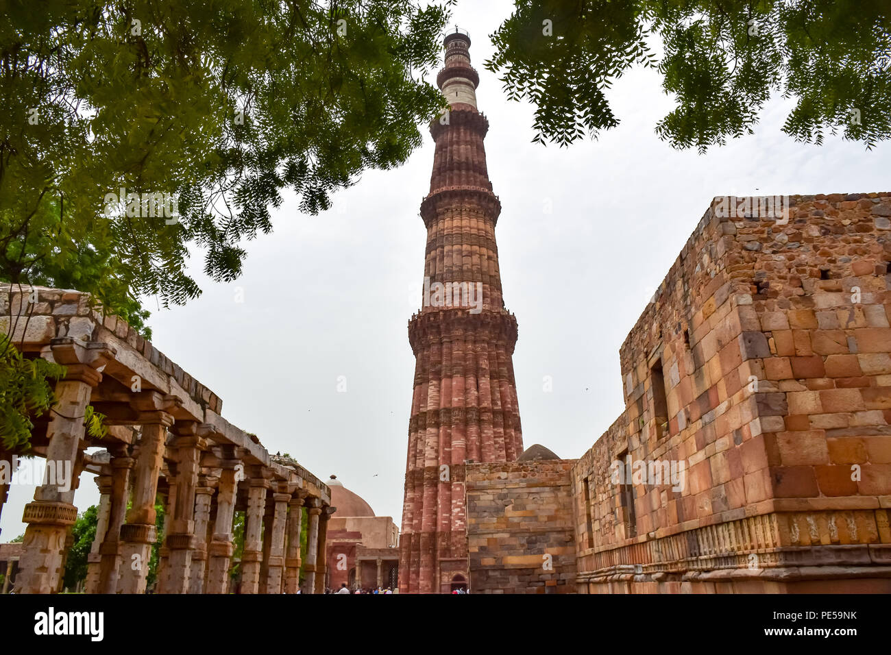 This photo seen Quwwat-ul-islam mosque made of red and yellow sand stone  ,has features of hindu as well as Islamic architecture stands tall within the Qutub complex in Delhi India. Qutub Minar standing 73 meters high at Delhi, is the tallest brick minaret and UNESCO heritage site. It represents Indo -Islamic architectural style, built by Qutb-ud-Din Aibak as a victory Tower in 1192 A.D. Stock Photo