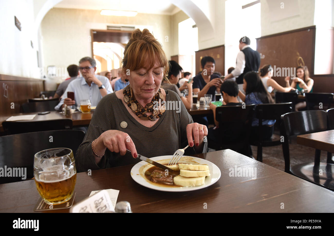 Woman with glass of traditional beer and classic Czech food at Lokal Dlouhaaa beer pub restaurant in Prague, Czech Republic Stock Photo