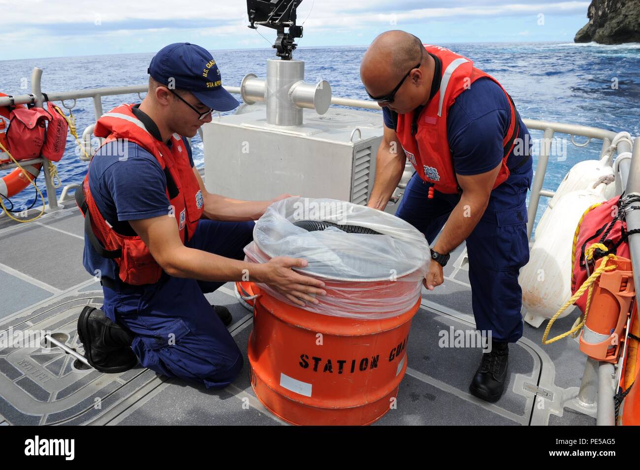 150930-N-ZB122-005 SANTA RITA, GUAM (Sept. 30, 2015) – Off the coast of Naval Base Guam, U.S. Coast Guard  Boatswain's Mate 3rd Class  John Jordan-Bertucci (left) and Boatswain's Mate 2nd Class Juan Jaijeron prepare to demonstrate how to use a Honda de-watering portable pump (p-6) for removing excess water on boats on Sept. 30. Based on Naval Base Guam, the U.S. Coast Guard Apra Harbor's primary missions here include search and rescue, law enforcement and protecting of living marine resources and critical infrastructures in and under the water. (U.S. Navy photo by Mass Communication Specialist Stock Photo