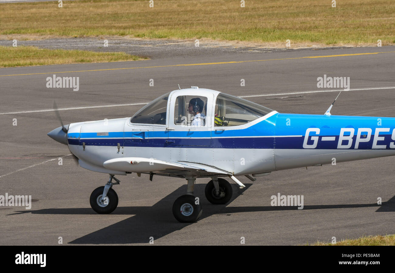 Close up view of a fixed wing two seat light aircraft. A pilot is in the cockpit. Stock Photo