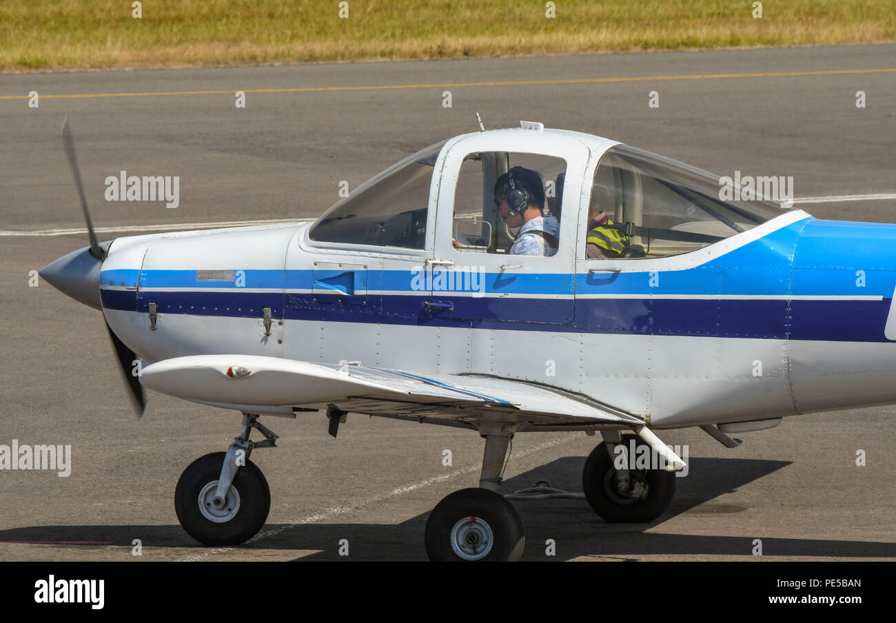 Close up view of a fixed wing two seat light aircraft. A pilot is in the cockpit. Stock Photo