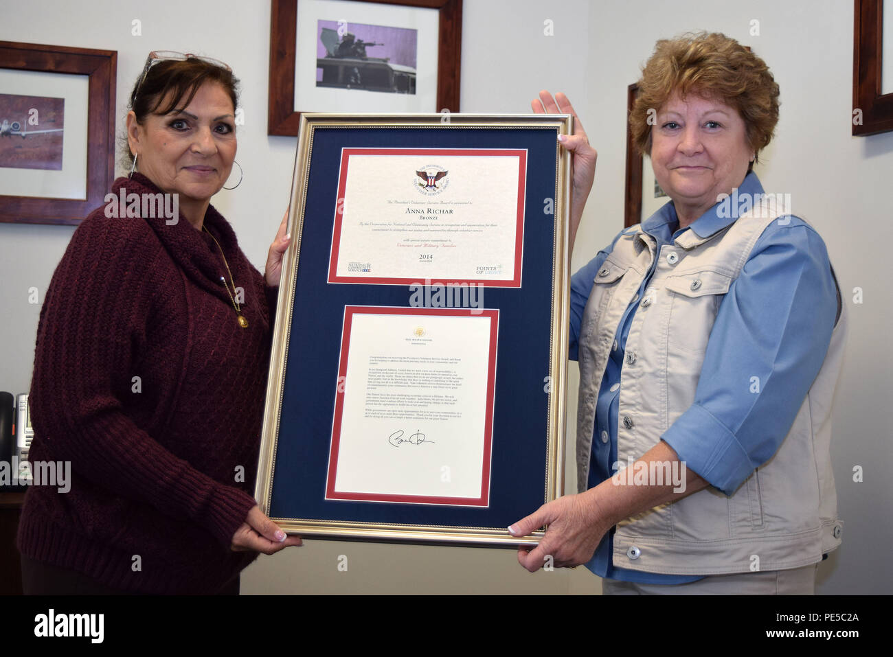 Anna Richar (left), Horsham Air Guard Station’s Airman & Family Readiness Center program manager, holds the President’s Volunteer Service Award alongside Jenny Papas, Friends of the Family Readiness Group, a 501(c)(3) organization, president Oct. 4, 2015, at the Wing headquarters building, Horsham Air Guard Station, Pennsylvania. Richar earned the accolades for her work with veterans and military families in 2014. (U.S. Air National Guard photo by Master Sgt. Chris Botzum/Released) Stock Photo