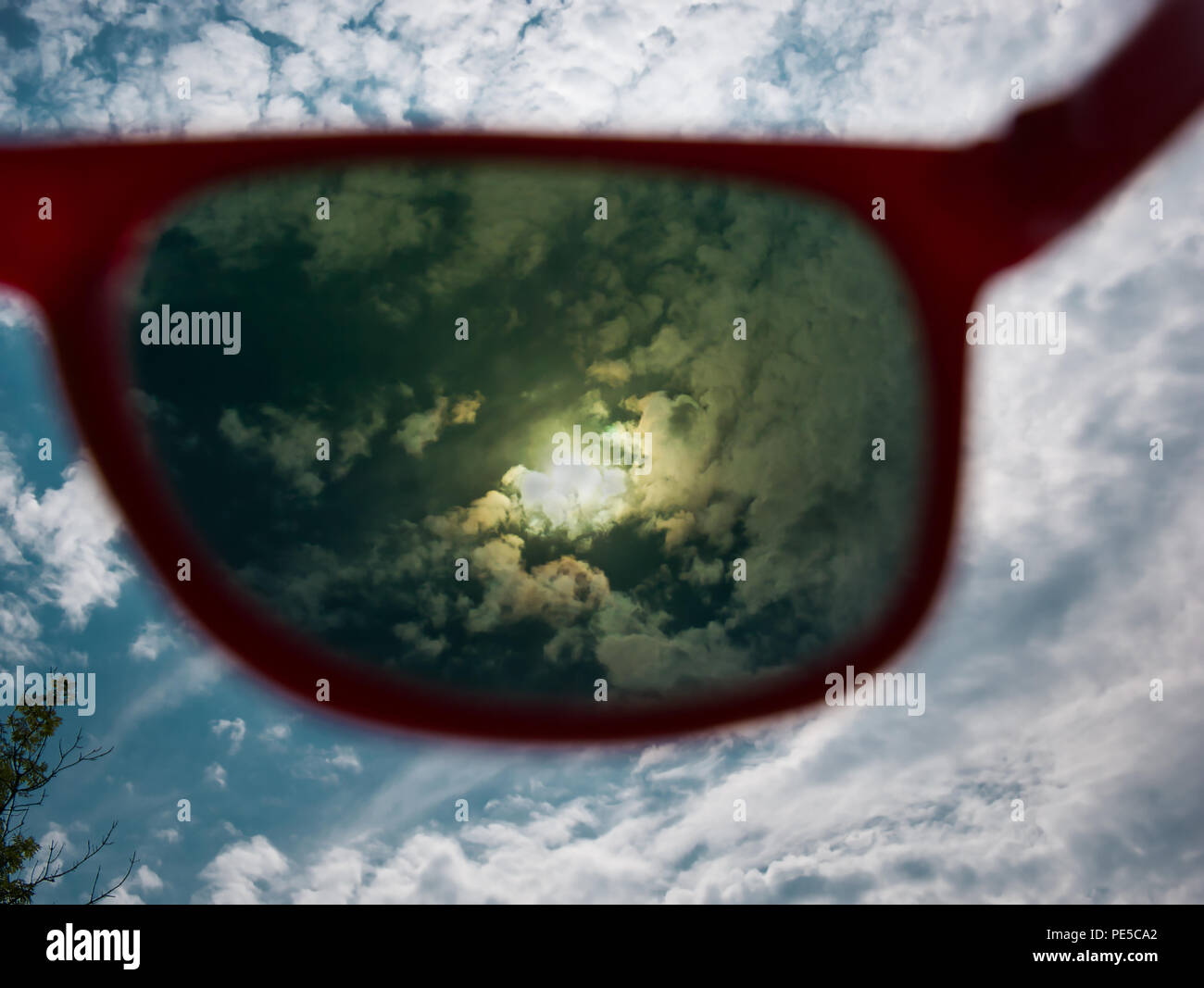 Direct view of the sun through red sunglasses with UV protection Stock Photo