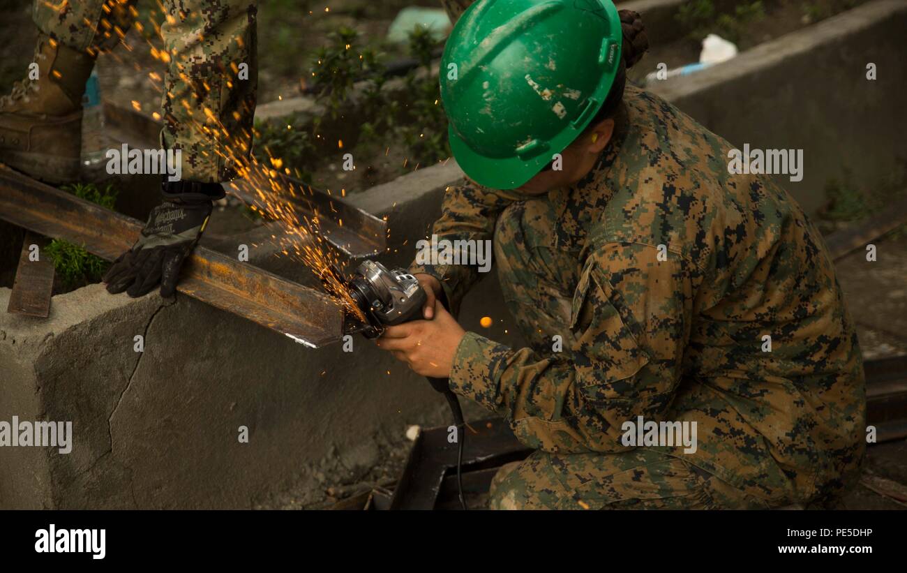 Lance Cpl. Jessica Pak, from Garwood, New Jersey, grinds metal while working on the humanitarian civic assistance project at Binduyan Elementary School Sept. 27, during Amphibious Landing Exercise 2015 (PHIBLEX 15). PHIBLEX 15 is an annual, bilateral training exercise conducted by members of the Armed Forces of the Philippines alongside U.S. Marine and Navy Forces. It focuses on strengthening the partnership and relationships between the two nations across a range of military operations, including disaster relief and complex expeditionary operations. Pak was preparing the metal to be welded to Stock Photo