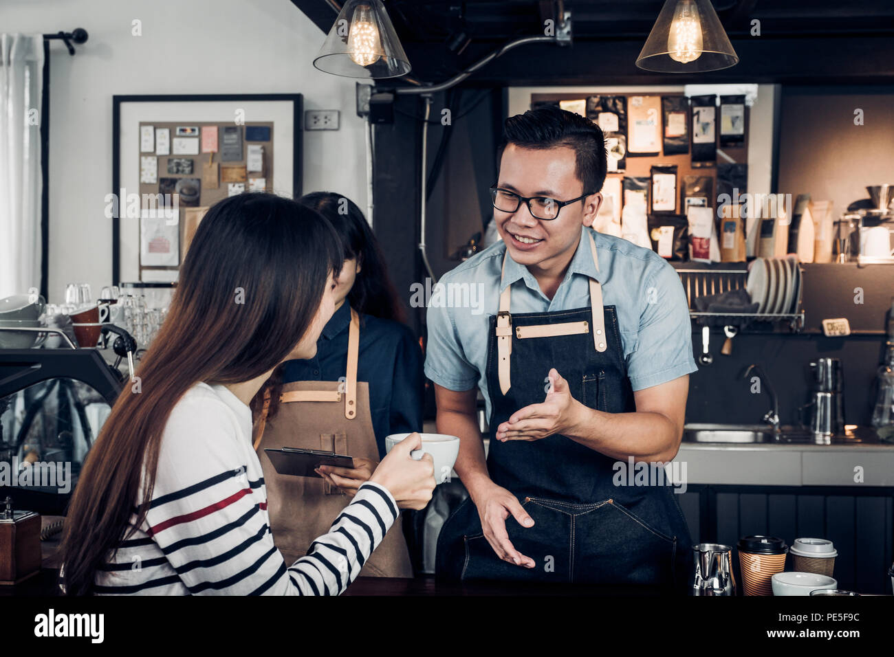 Male barista talking with customer about tasted of coffee cup with