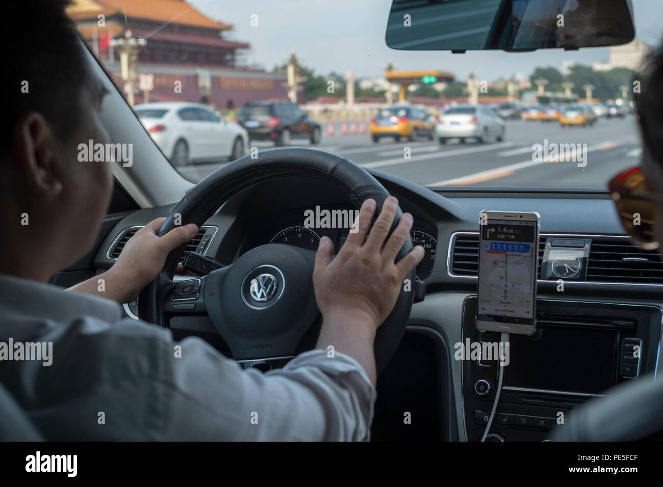 A Didi Premier car drives past the Tiananmen Gate in Beijing, China. Didi Premier offers a higher-end premier mobility experience with luxury vehicles Stock Photo