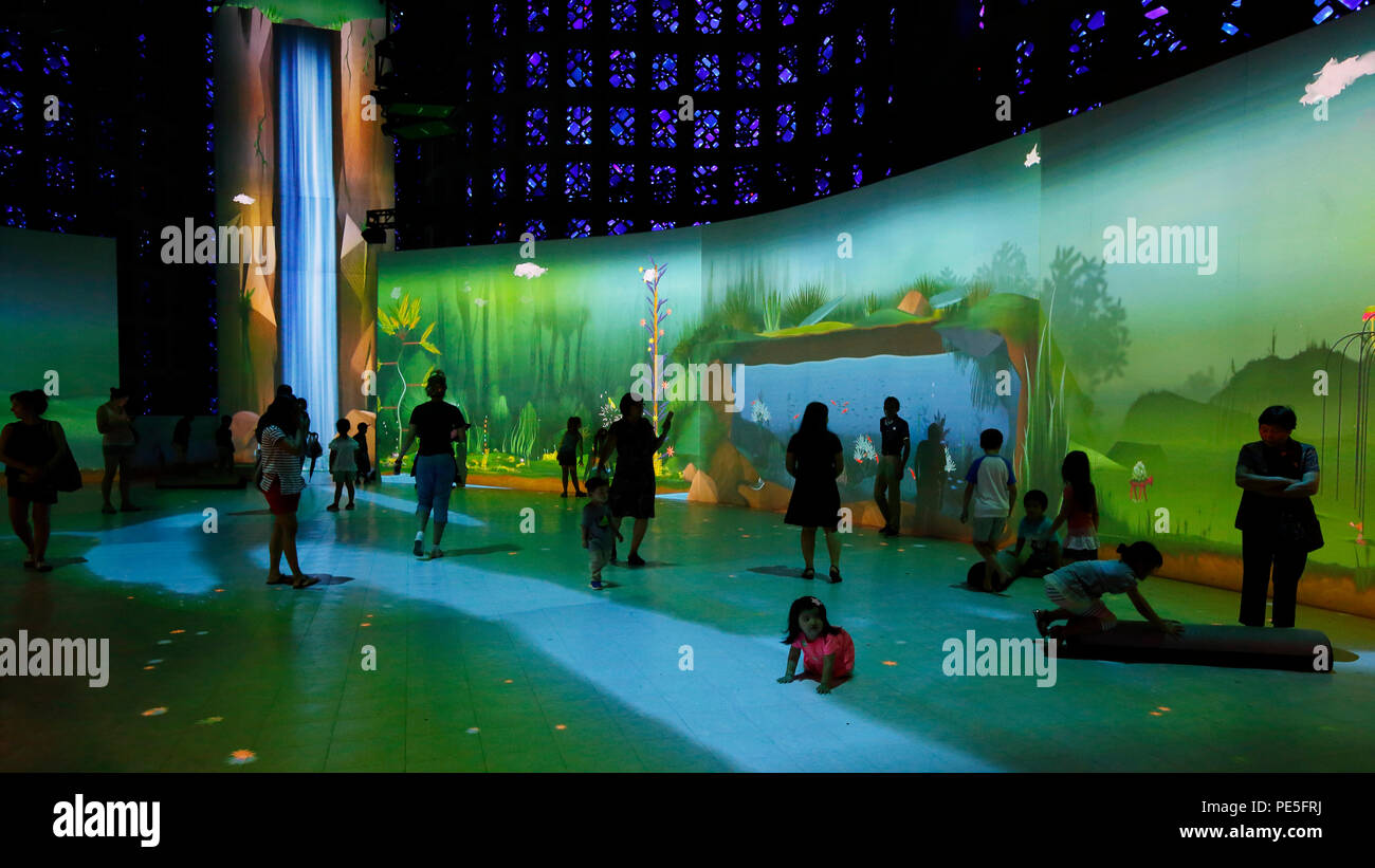 People in the Connected Worlds immersive, interactive ecosystem exhibit at the New York Hall of Science Stock Photo