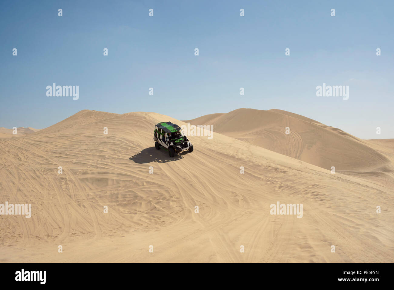 Dune buggy driving down a sand dune. Huacachina, Ica, Peru. Jul 2018 Stock Photo
