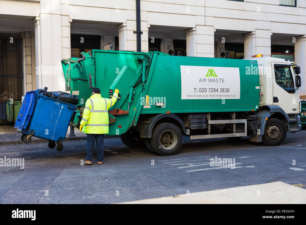 LONDON, ENGLAND 10 APRIL 2017 Garbage collector loads trash into his truck in London