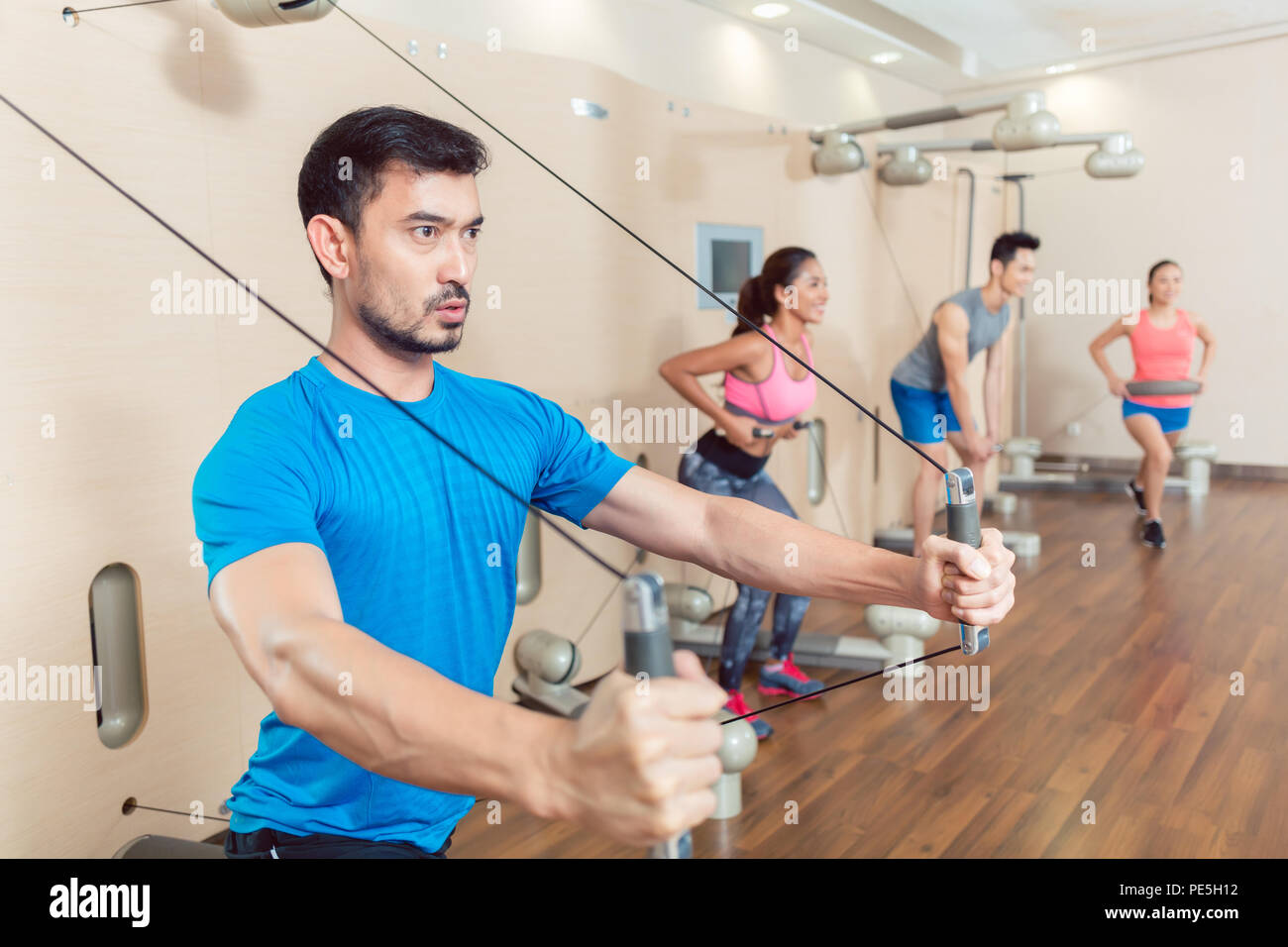 Determined young man exercising with resistance bands Stock Photo