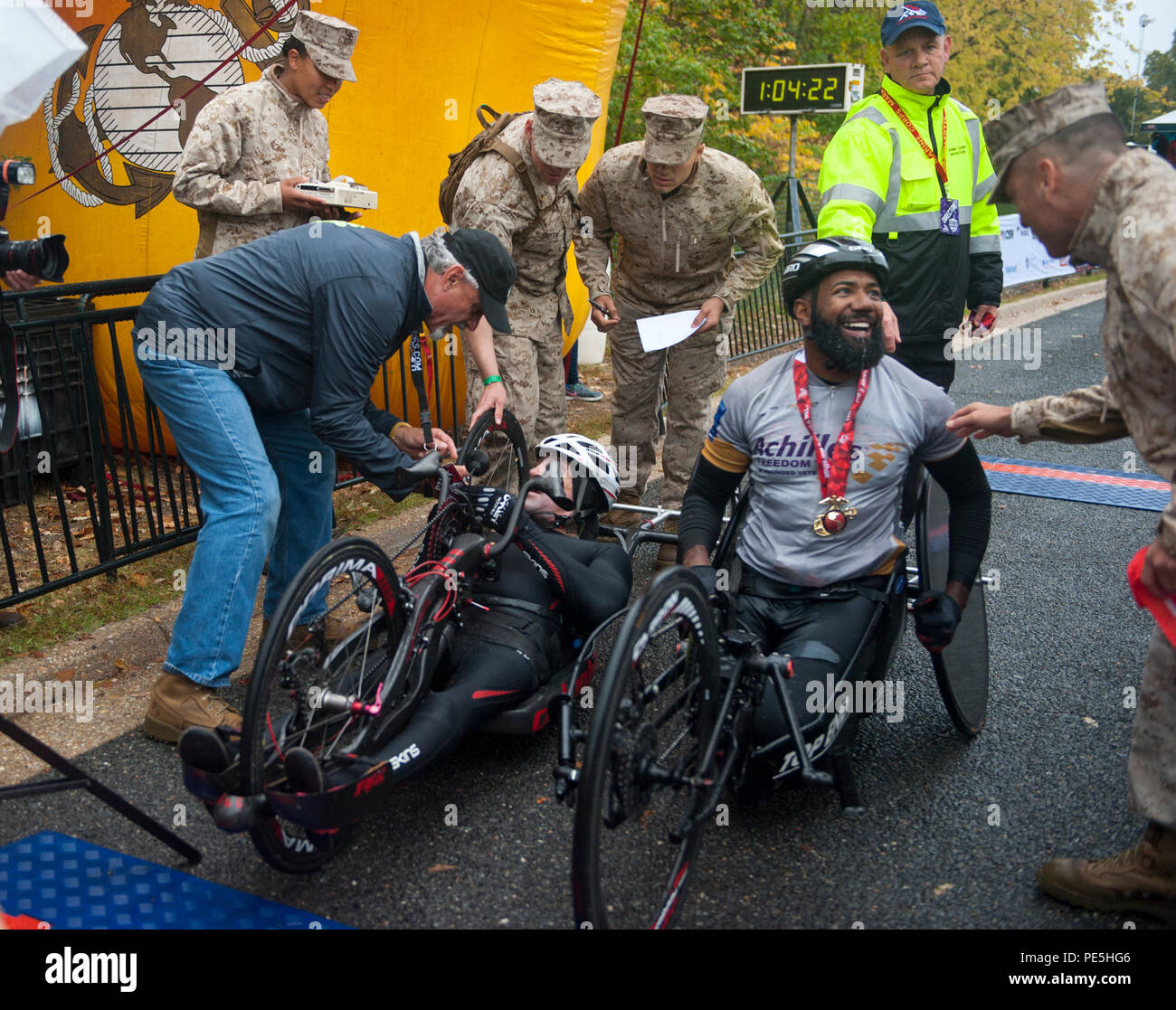 A hand cycle particpant (right) and finisher of the 40th Annual Marine Corps Marathon is congratulated Col. Josheph M. Murray, commander of Marine Corps Base Quantico in Arlington, Va., Oct. 25, 2015. Also known as 'The People's Marathon,' the 26.2-mile race drew roughly 30,000 participants to promote physical fitness, generate goodwill in the community, and showcase the organizational skills of the Marine Corps. (U.S. Marine Corps photo by Sgt. Alexandria Blanche/Released) Stock Photo