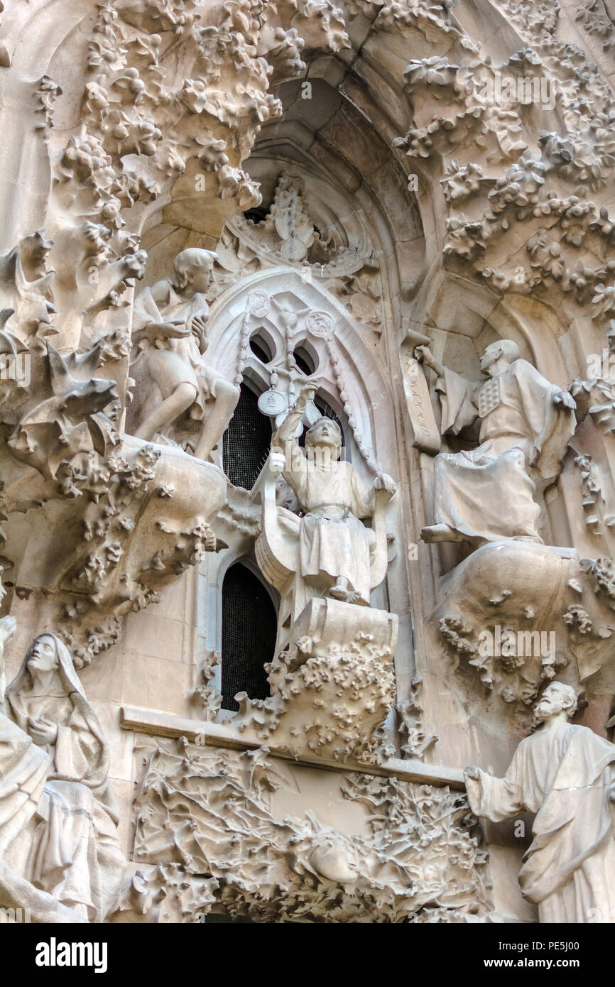 Sagrada Familia exterior, Nativity Facade, The Faith Portico, The finding in the Temple scene. Young Jesus is speaking wisely with the priests of the  Stock Photo
