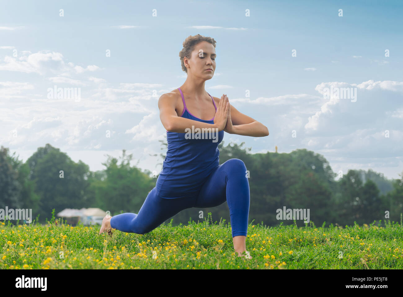 Fitness woman breathing slowly while standing in yoga pose Stock Photo