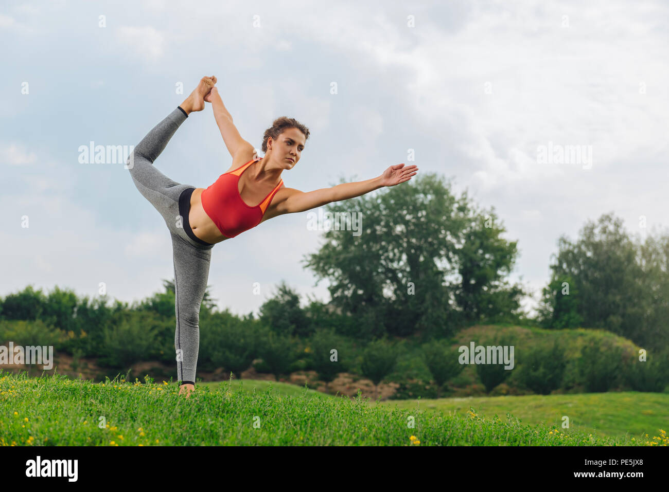 Dark-haired gymnast woman improving her balancing and stretching Stock Photo