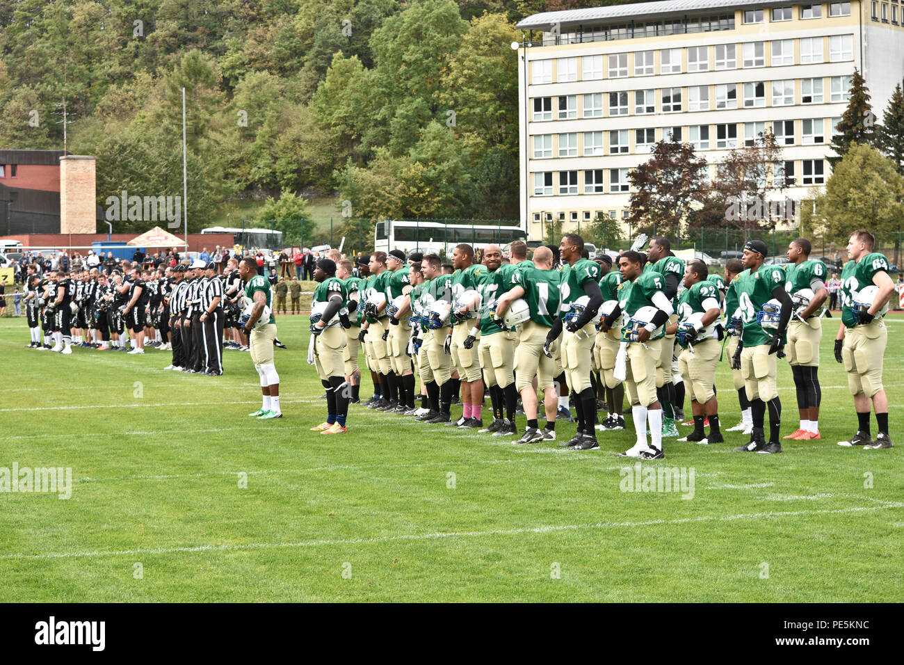 Troopers from the 2nd Cavalry Regiment's football team stand side-by-side with the Prague Black Panthers as they prepare for each country's national anthem and the coin toss before starting their game in Cesky Krumlov, Czech Republic, Sept. 26, 2015. The team participated in an American football game with the local Czech Republic semi-professional football team as the unit helped to commemorate the 70th anniversary of Cesky Krumlov's liberation during World War II while also demonstrating the U.S. commitment to their NATO and Czech allies. (U.S. Army photo by Sgt. William A. Tanner/released) Stock Photo